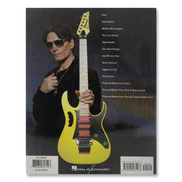 image of the back of the steve vai- modern primitive album artwork on a guitar tab book. there is an image of steve vai, wearing sunglasses and all black clothing. he holds a yellow electric guitar towards the camera. next to him in white text is the track listing for the album.