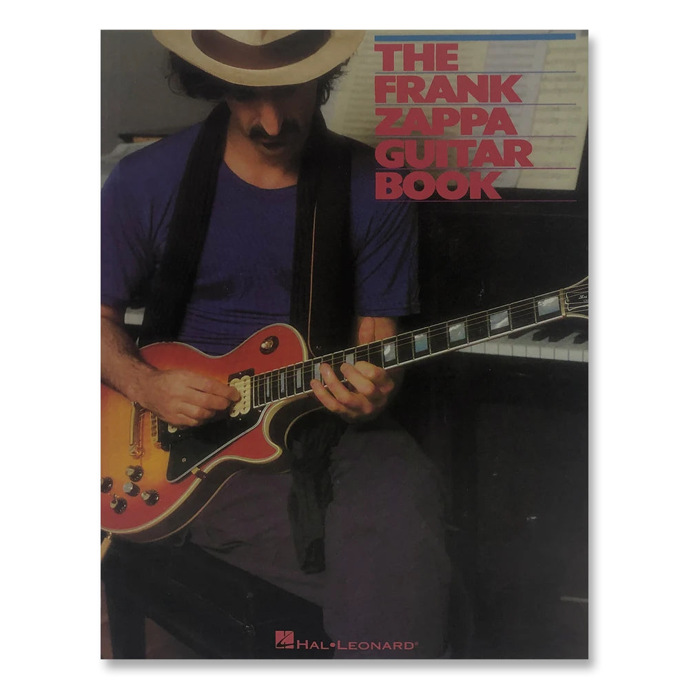 image of a guitar book against white background. the cover art for the book is a man sitting in a chair playing an electric guitar. the man looks down at the guitar and is wearing a tan fedora and dark clothing. to the right of his head in red text reads "the frank zappa guitar book".