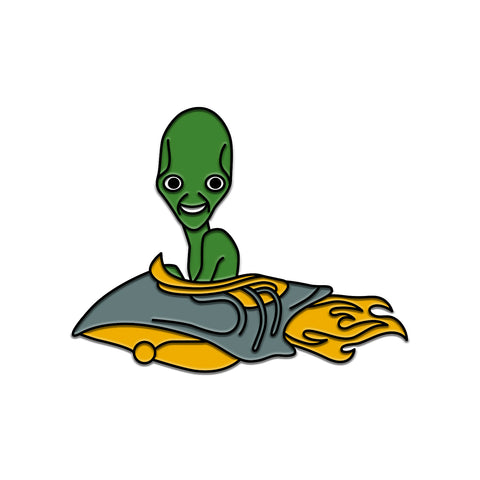 Enamel pin against white background. it is a smiling green alien in a grey and yellow rocketship with fire coming out of the back