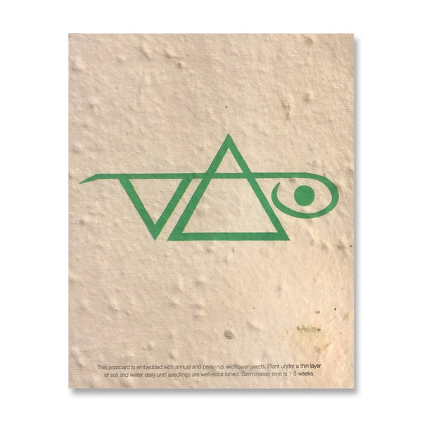 Light beige colored postcard with seedling indents in it against white background. the postcard has a green steve vai logo on it. The steve vai logo makes the word "vai" with an upside down triangle, a right side up one, and a line going across the triangles with a curl at the end next to the triangle that is upright.  