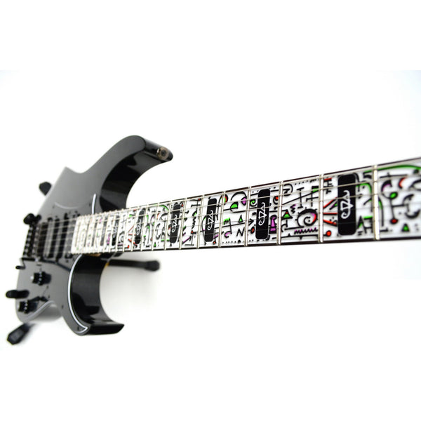 image of a guitar against a white background. there is a fret protector on the guitar. it is white with pink/red, green, and black symbols all over it. some of the frets have a black rectangle with a white steve vai logo on it. The steve vai logo makes the word "vai" with an upside down triangle, a right side up one, and a line going across the triangles with a curl at the end next to the triangle that is upright. 