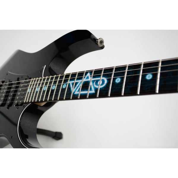image of a black guitar with a fret protector that is black with dark colored symbols throughout. descending from the center of the fret protector is a glowing light blue and white steve vai logo. The steve vai logo makes the word "vai" with an upside down triangle, a right side up one, and a line going across the triangles with a curl at the end next to the triangle that is upright.