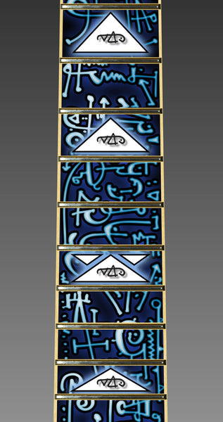 up close image of the fret protector. it has a lot of abstract shapes in black, white, and light blue. some of the spaces have white triangles with a black outline with the steve vai logo in the center. The steve vai logo makes the word "vai" with an upside down triangle, a right side up one, and a line going across the triangles with a curl at the end next to the triangle that is upright. 