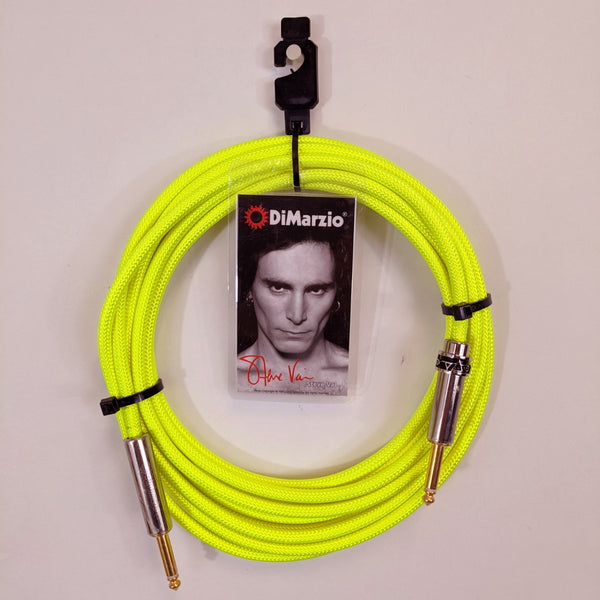 image of a lemon yellow guitar cable with gold ends against white background. the black cable has a tag that features a black and white photo of steve vai, photographed from the neck up. above steve's head reads "dimarzio" in white text. below steve in red cursive are the words "steve vai".