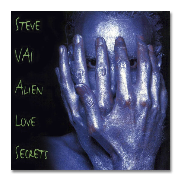 Image of the steve vai "alien love secrets" cd album artwork. there is a black cover with a person covered in blue and silver paint photographed from the neck up. their hands cover their face but you can only see their eyes. to the left of this in green descending text reads "steve vai, alien love secrets" .