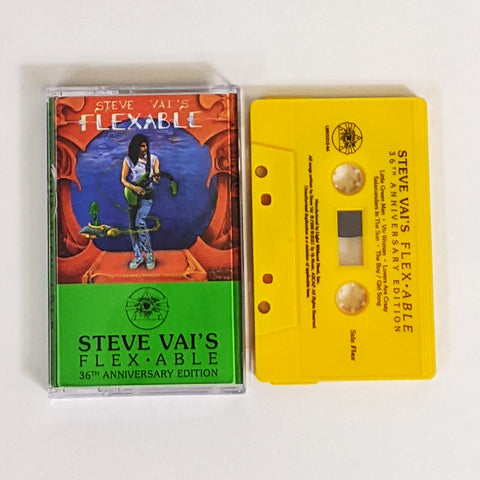 image of a yellow cassette and clear cassette tape case with steve vai's flexible artwork on it. the artwork is red with a blue circle in the center. standing by the blue circle is steve vai playing a green guitar. the neck of the guitar droops down. swirling around steve is an alien in a small ship. above this in blue and white text reads "steve vai's flexable".